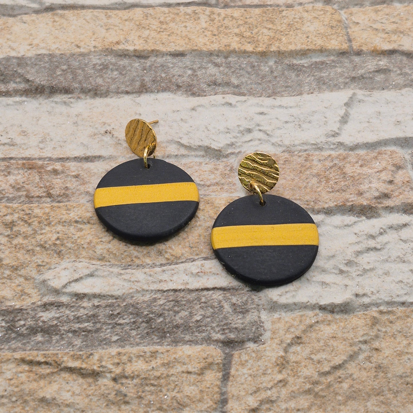 Glanzstreif - schwarze runde Ohrringe aus Polymer Ton mit einem goldenen Streifen