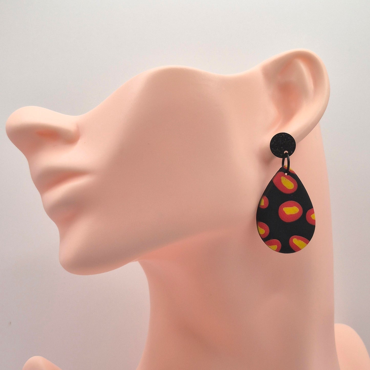 Feuerpunkt – Tropfenförmige Statement-Ohrringe in Schwarz mit leuchtendem Flammenmuster